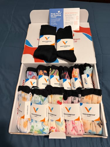 Customer's Viasox EasyStretch Socks 5-Pack Bundle inside an open shipping box, showing many pairs with patterned designs.