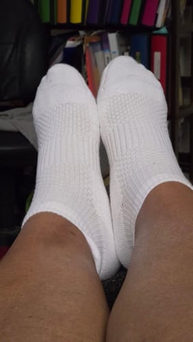 Customer's feet wearing white ankle compression socks, showing a snug and cozy fit.