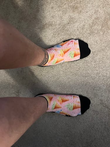 Customer's feet wearing pink ankle compression socks featuring an ice cream cone pattern.
